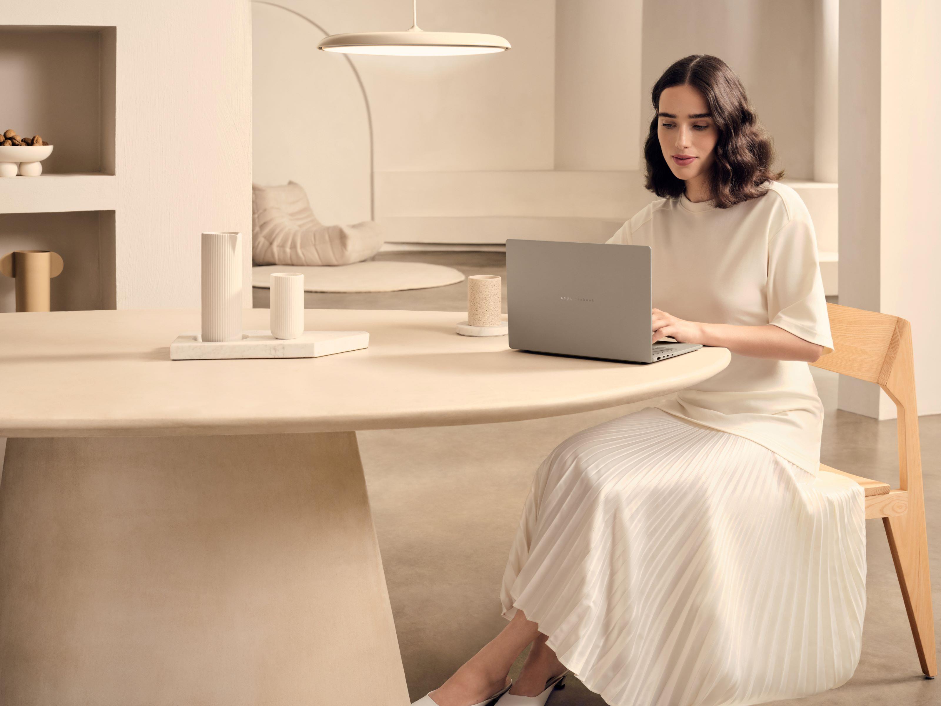 A woman using an ASUS laptop at a table